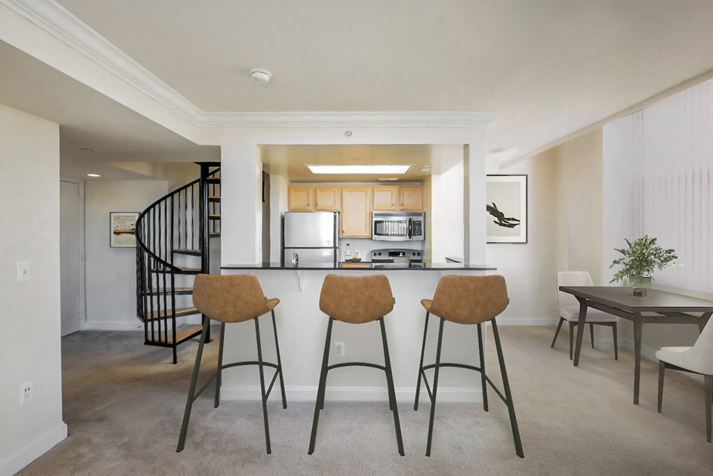 a living room with a kitchen and a bar with three stools
