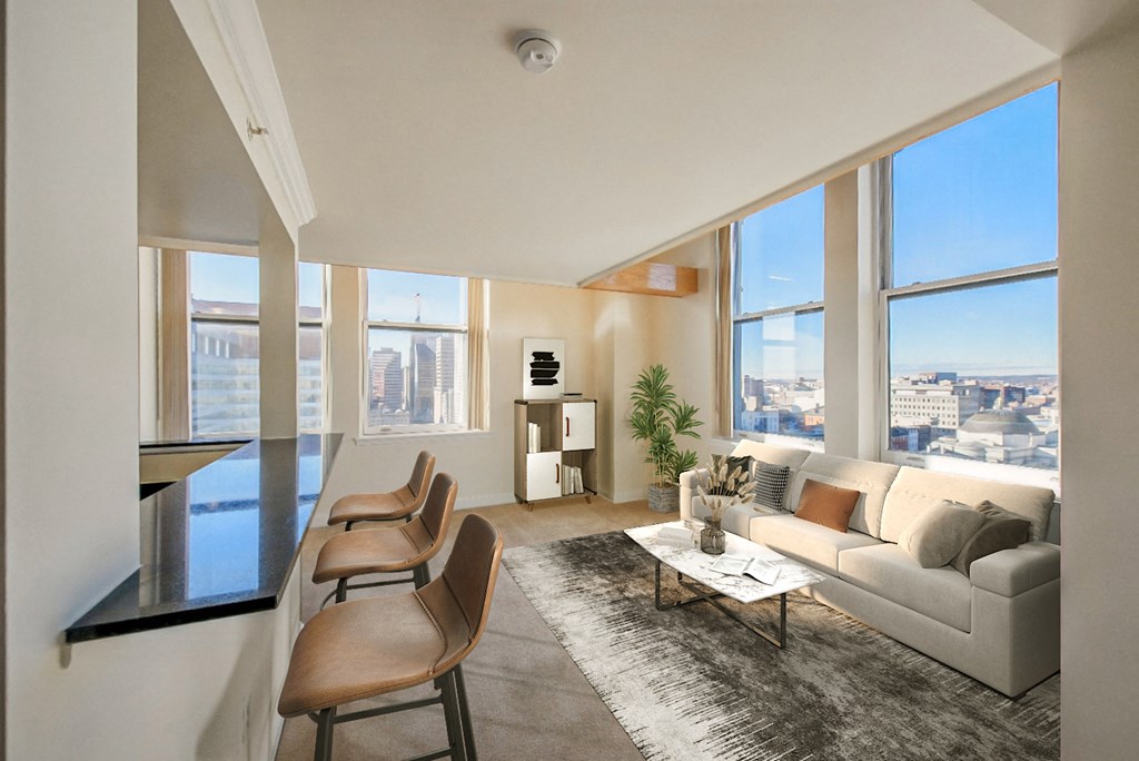 a living room with a couch and chairs and a large window