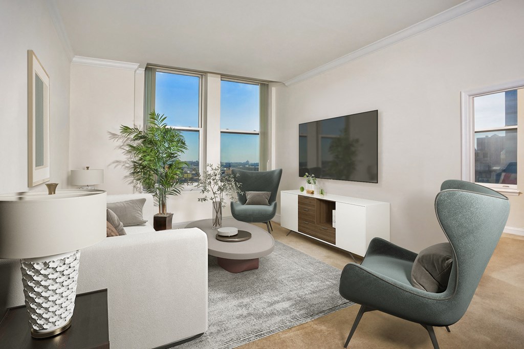 a living room with white furniture and large windows