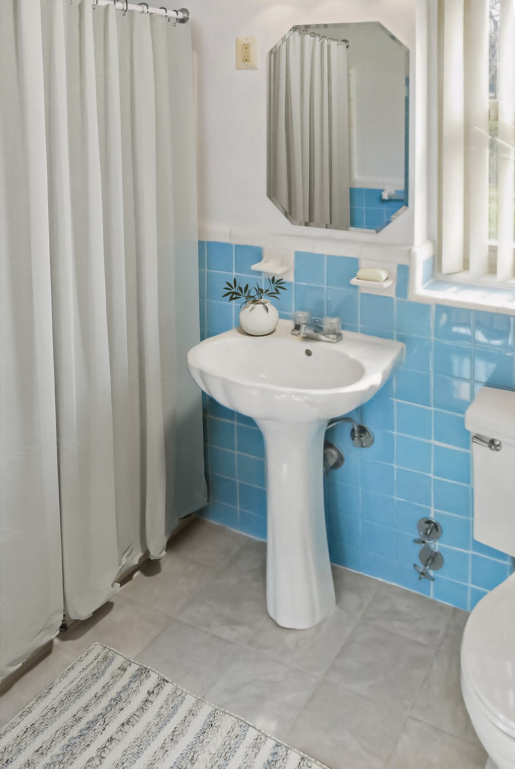 a small bathroom with a sink and a shower curtain