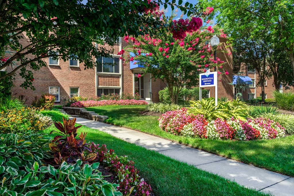 a sidewalk in front of a brick building with a sign