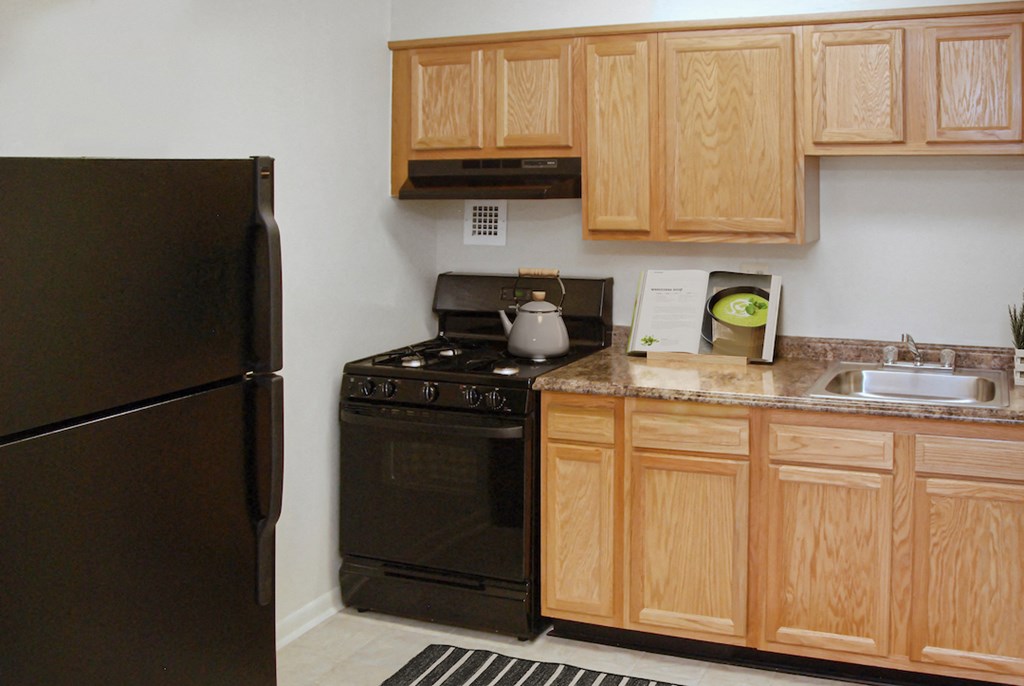 a kitchen with black appliances and wooden cabinets