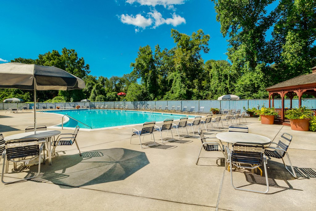 a swimming pool with tables and chairs and umbrellas
