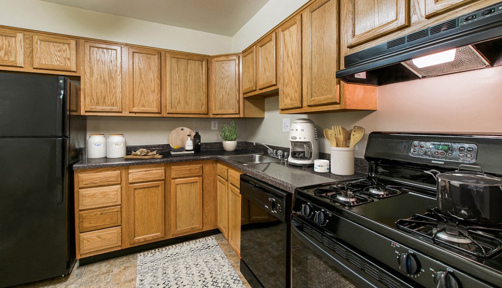 a kitchen with black appliances and wooden cabinets
