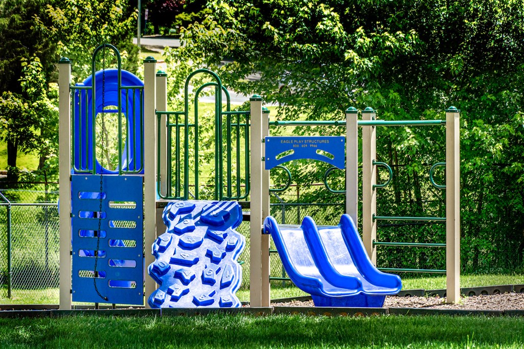 a playground with blue chairs and a blue gate