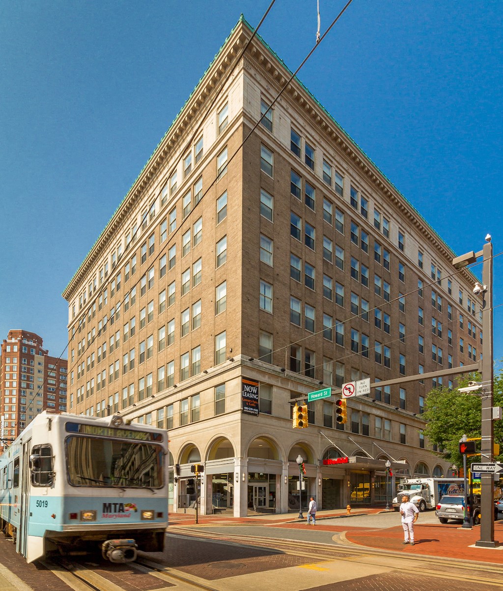 a bus driving past a tall building on a city street