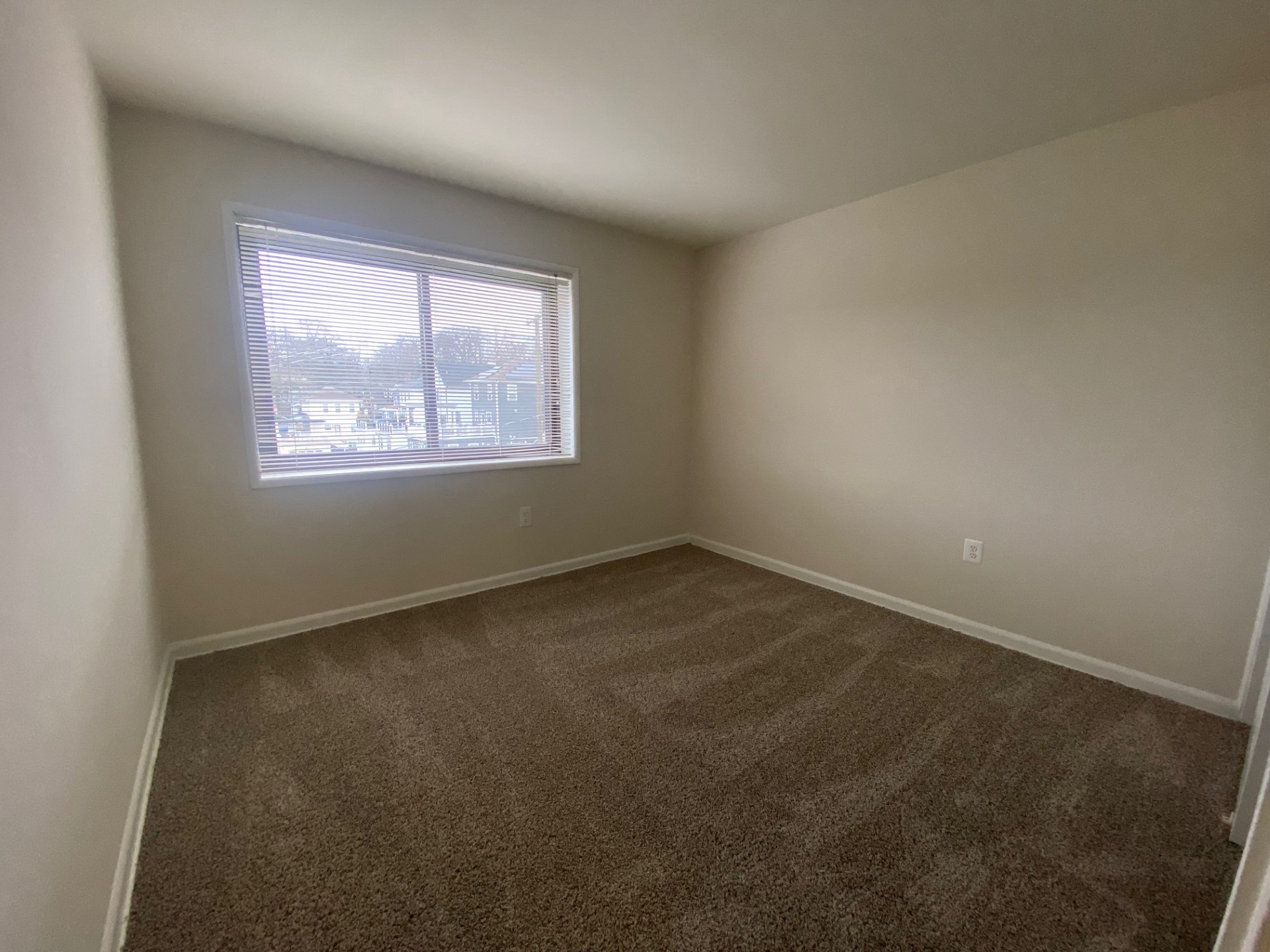 an empty living room with carpet and white doors