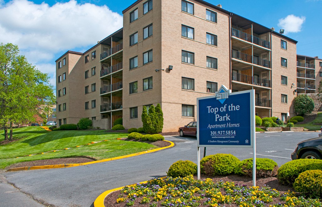 top of the park sign in front of an apartment building