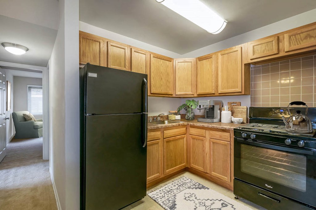 a kitchen with black appliances and wooden cabinets