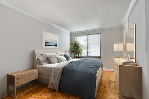 a bedroom with a bed and a dresser and a window