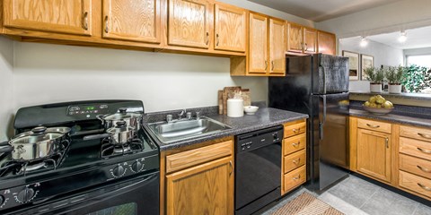 a kitchen with black appliances and wooden cabinets