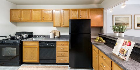 a kitchen with black appliances and wooden cabinets