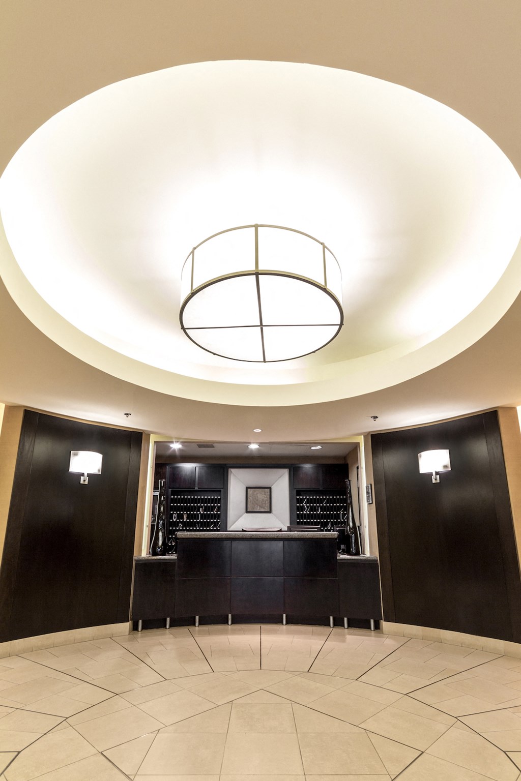 a large white circular ceiling with a bar in a lobby