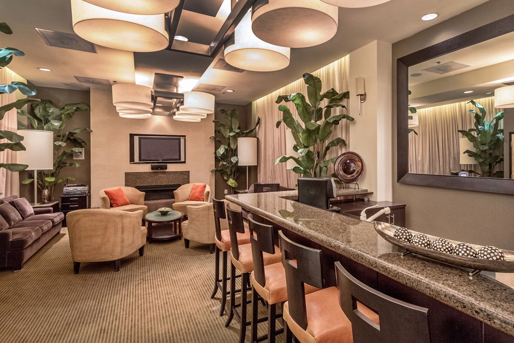 a lobby with a bar and chairs and a television