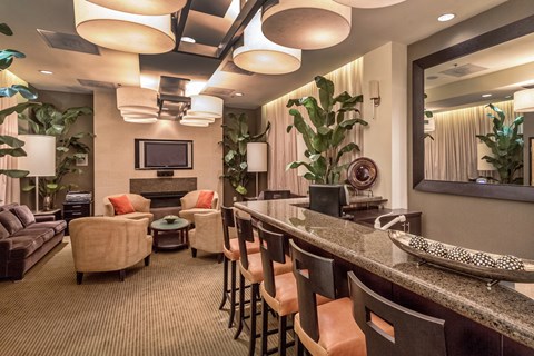 a lobby with a bar and chairs and a television