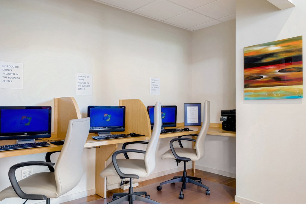 a row of computers on desks in a room