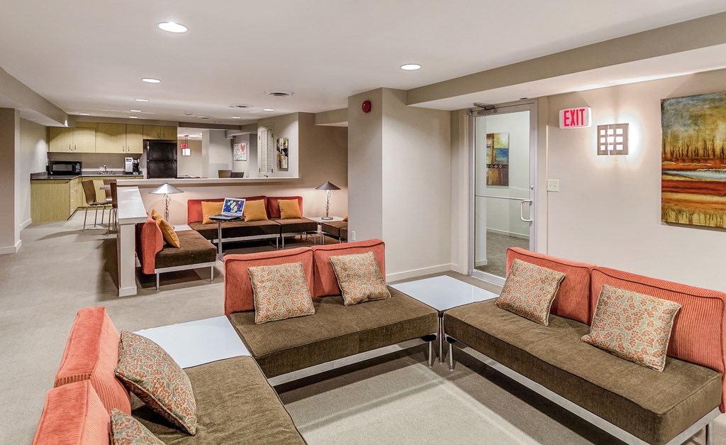 a living room with couches and chairs and a kitchen