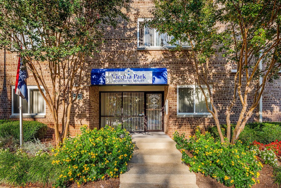 a brick building with a blue sign in front of a gate