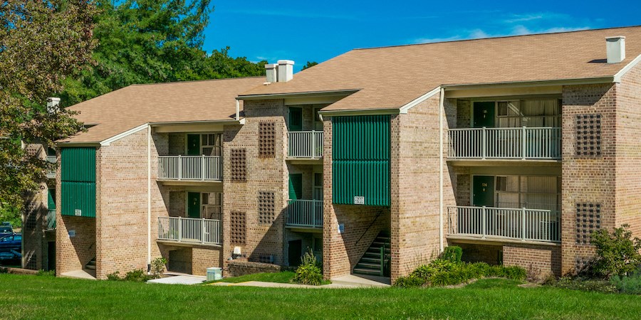 an apartment building with balconies and green doors