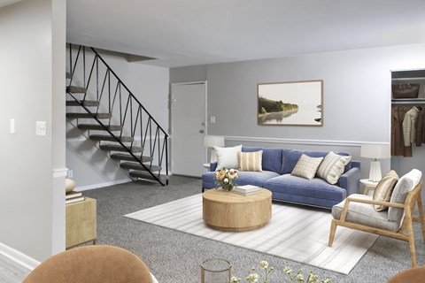 A living room with a blue couch, a coffee table, and a painting on the wall.