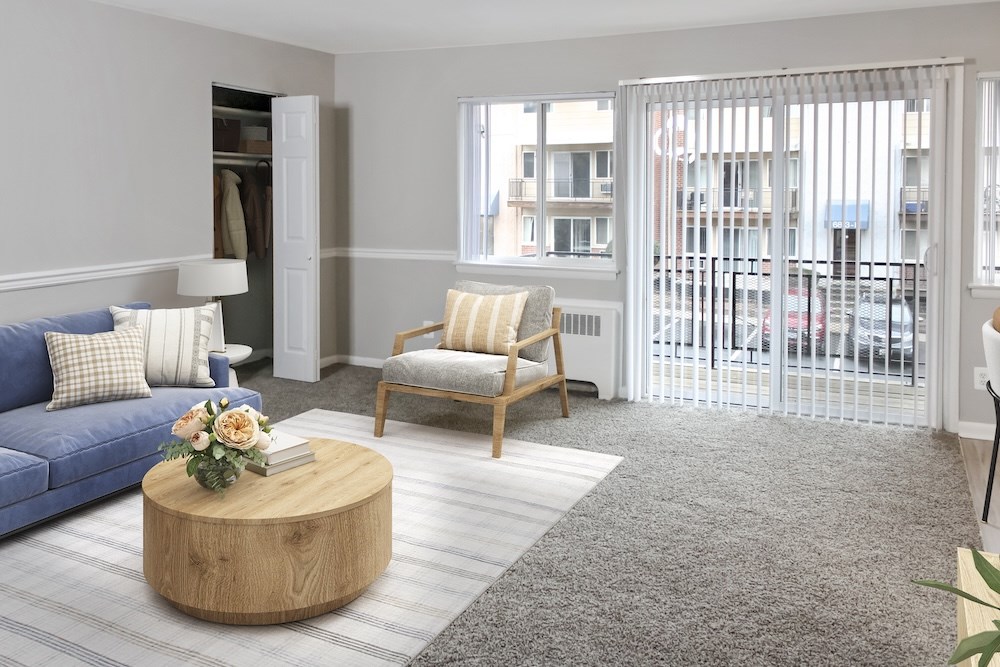 A living room with a blue couch, a wooden coffee table, and a striped chair.