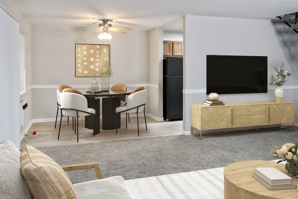 A living room with a black TV on a wooden stand and a dining table with chairs.