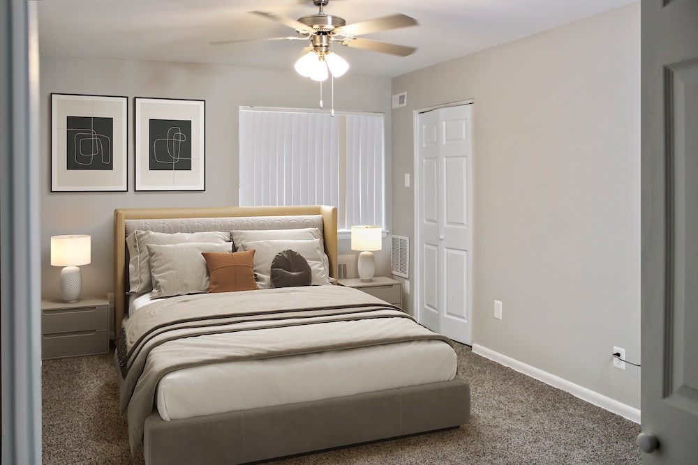 A bedroom with a large bed and two lamps.