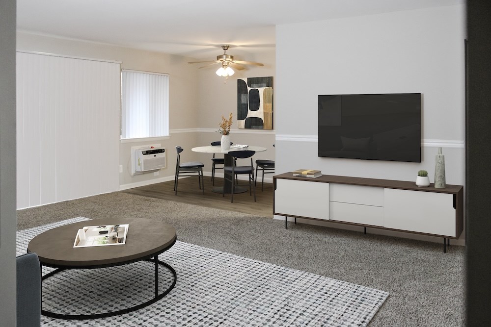 A living room with a television, a table, and chairs.