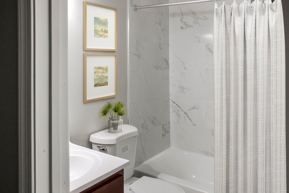 A white toilet sits next to a white sink in a bathroom.