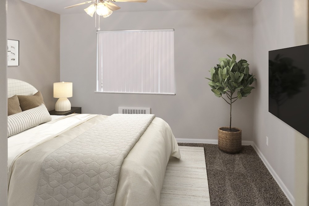 A bedroom with a large bed and a ceiling fan.