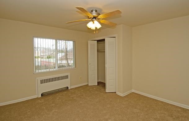 an empty room with a ceiling fan and a window