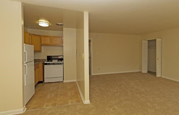 an empty kitchen with a stove and a refrigerator