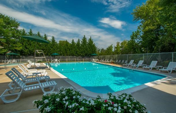 a large swimming pool with chairs and umbrellas