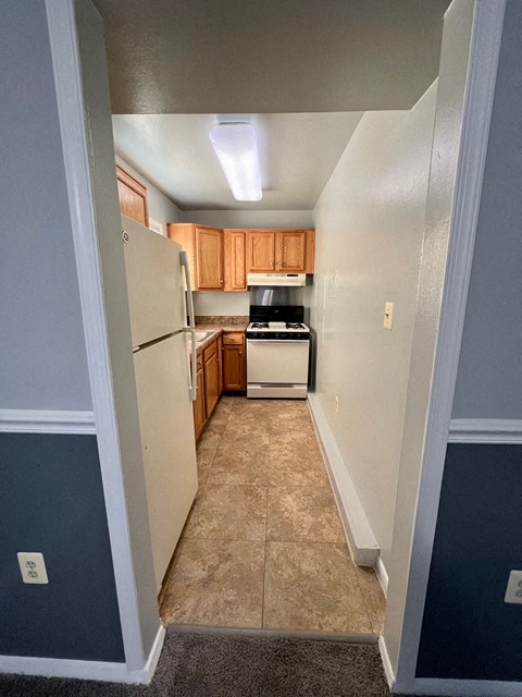 an empty kitchen with a refrigerator and a stove and