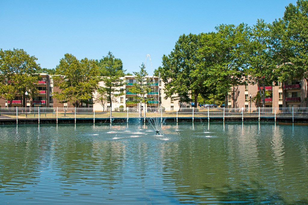 a fountain in the water with buildings in the background