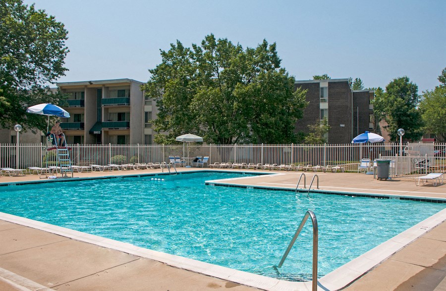 a swimming pool with an apartment building in the background