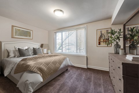 a bedroom with a bed and a dresser and a window