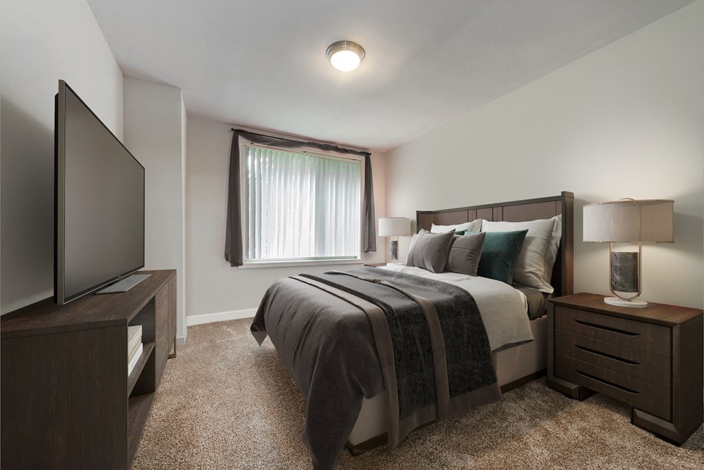 an empty bedroom with a bed and a tv