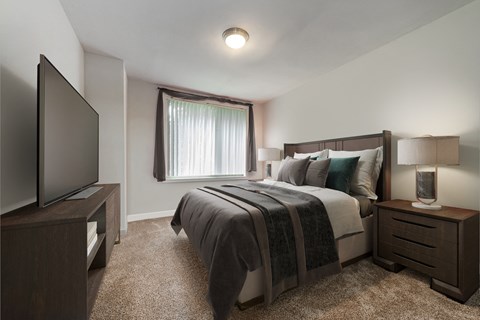 an empty bedroom with a bed and a tv