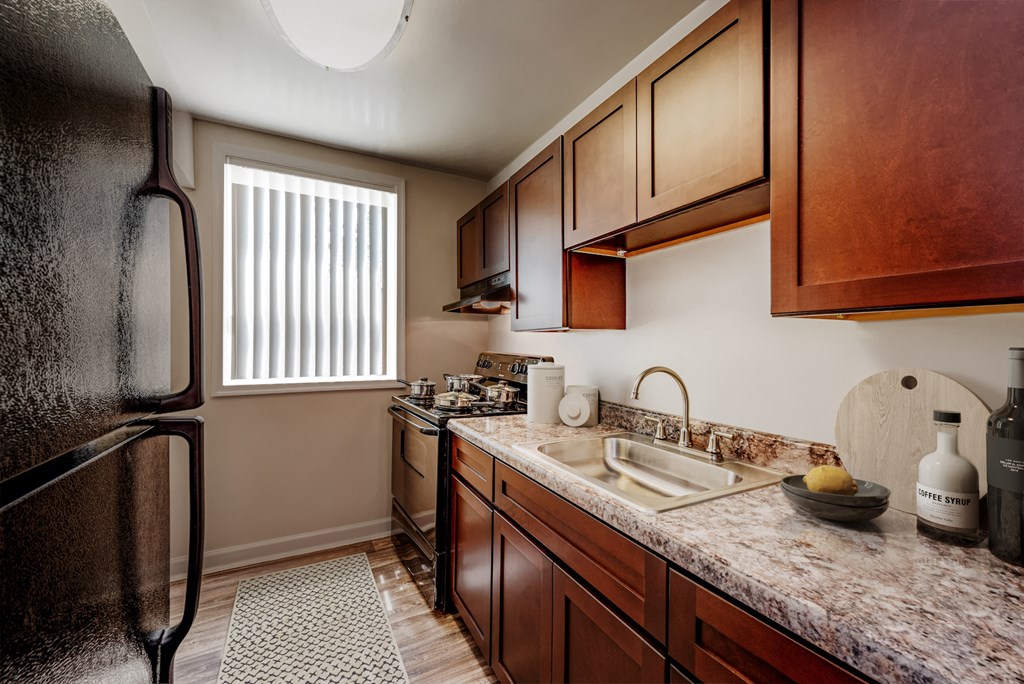 a kitchen with wooden cabinets and a sink and a refrigerator