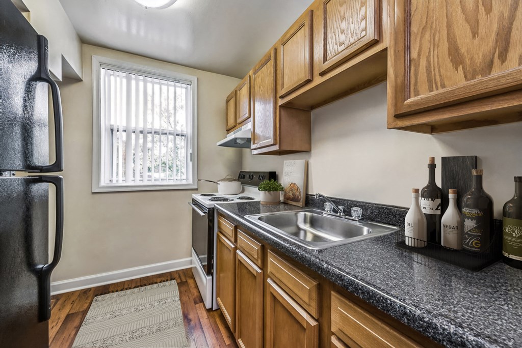 a kitchen with wood cabinets and granite counter tops and a sink