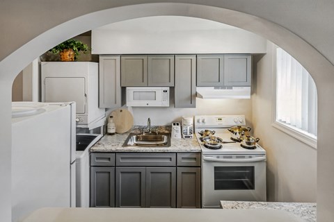 a kitchen with white appliances and gray cabinets