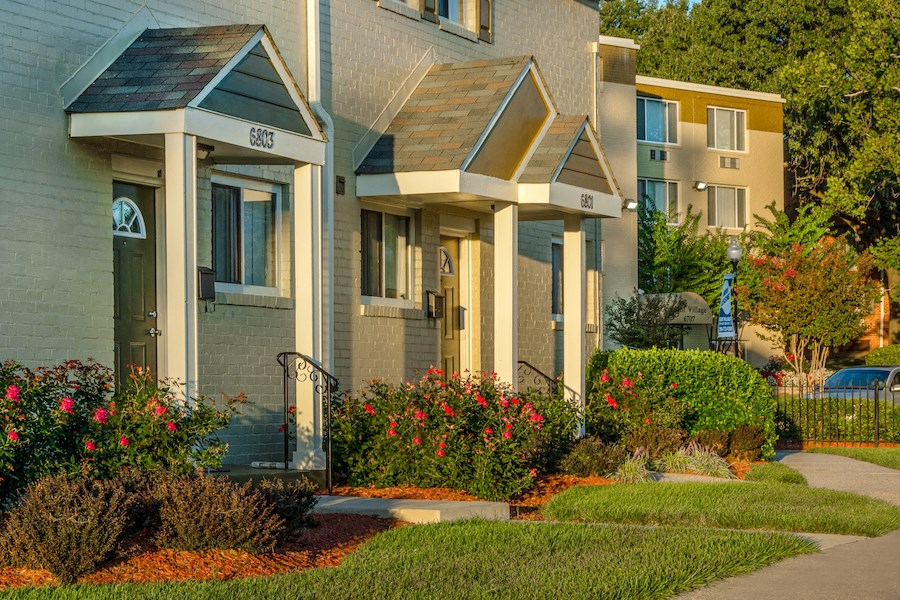 a row of houses with flowering plants in front of them