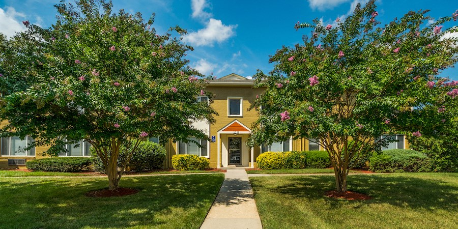a yellow house with two trees in front of it