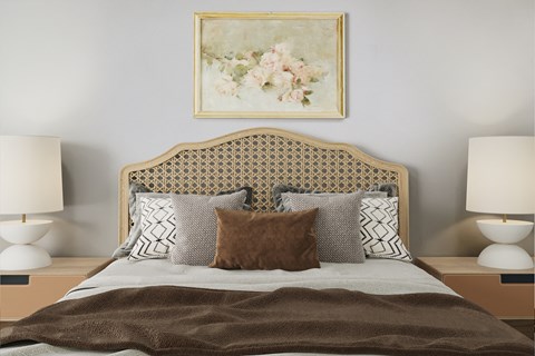 a bedroom with a bed with pillows and a painting on the wall