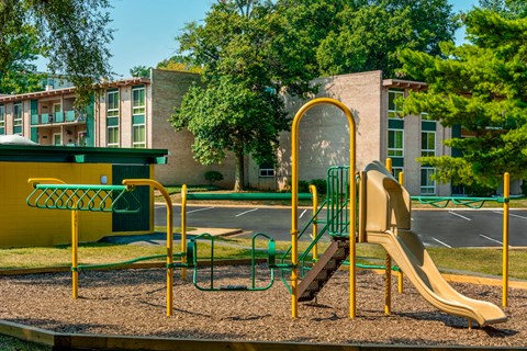a playground in front of a building with a slide