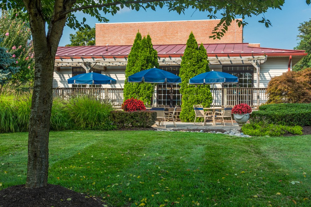 a patio with umbrellas in front of a building