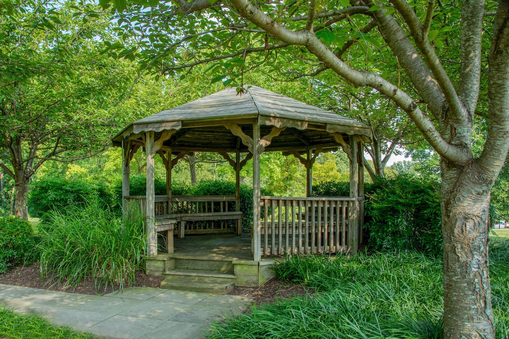 a gazebo with a bench in a park