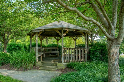 a gazebo with a bench in a park