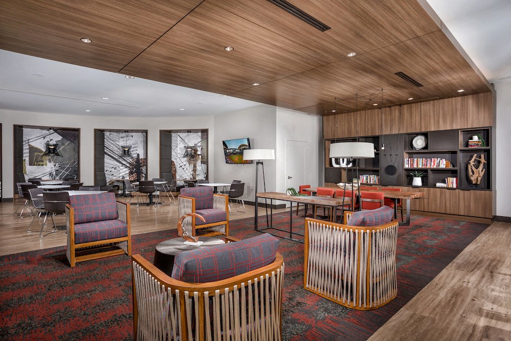 the lobby of a hotel with chairs and tables